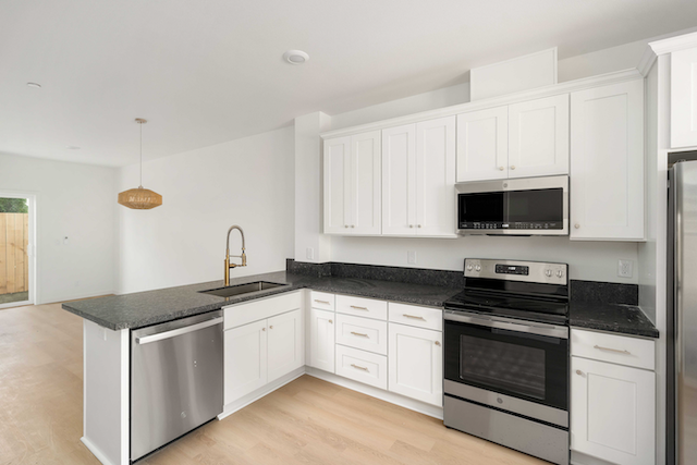 Kitchen with white cupboards wood floors